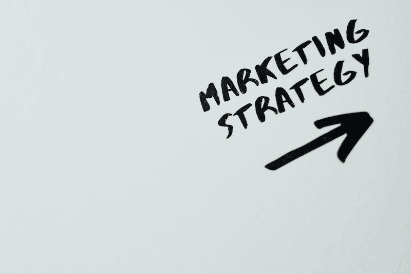 What Is Website Marketing? 13 The words "marketing strategy" above an arrow written with a marker