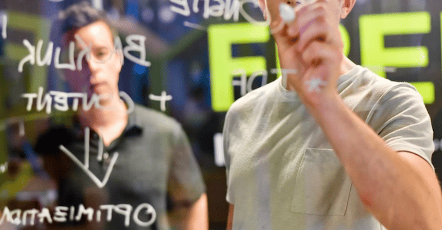 Who Is An SEO Consultant? 3 Two SEO consultants creating a marketing plan on a transparent board