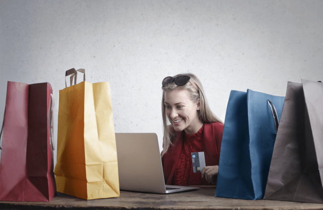 Looking For A WordPress Developer In Washington, DC? 6 A woman shopping online with multicolored bags around her