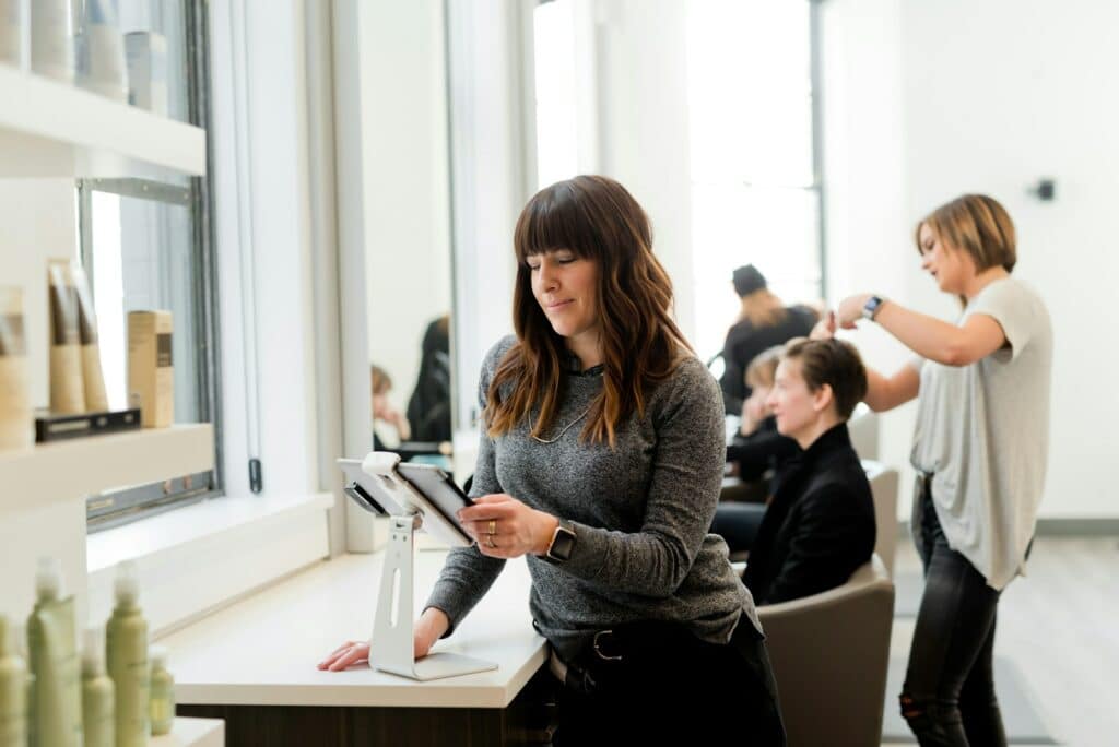 woman in gray sweater holding tablet computer