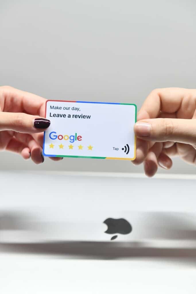 How to Get Google Reviews for Your Small Business 11 two hands holding a google credit card in front of an apple logo