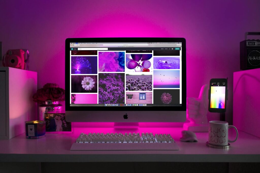 Wondering How to Create a Website For My Business? | Create a Secure and SEO-Optimized Business Website 14 Modern desk setup with neon lighting and a desktop computer displaying colorful images.