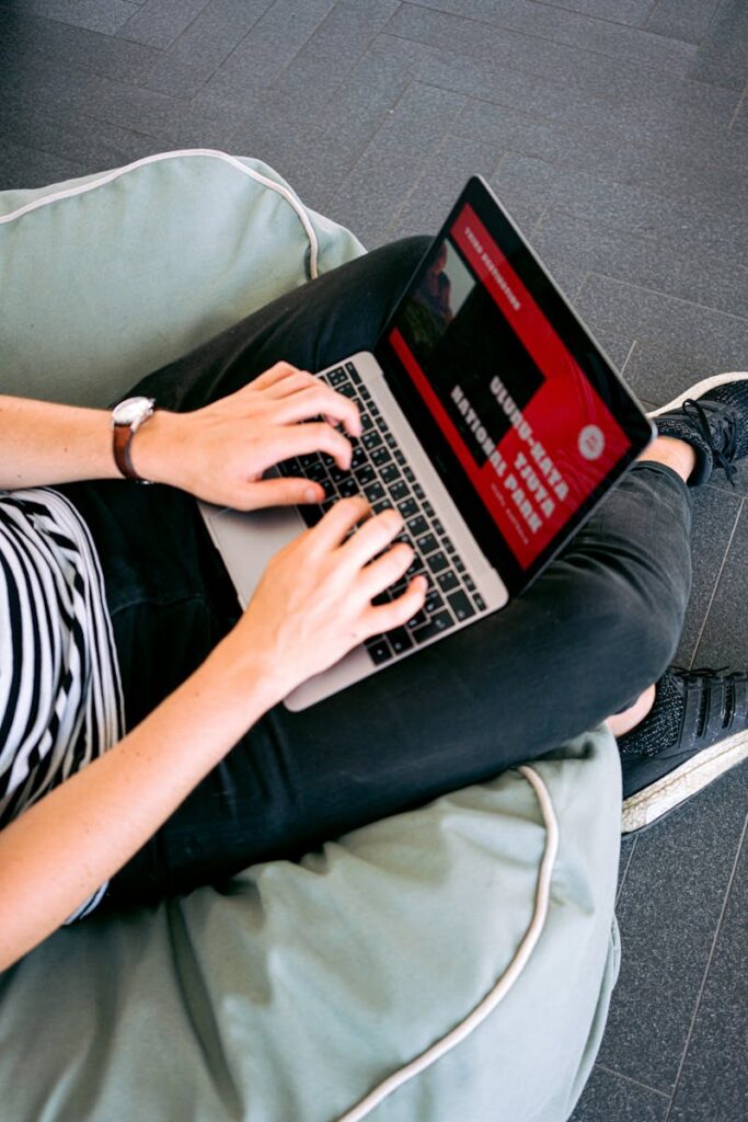 10 Inspiring Personal Website Ideas to Elevate Your Online Presence 16 Person working remotely on a laptop while sitting comfortably on a beanbag chair indoors.