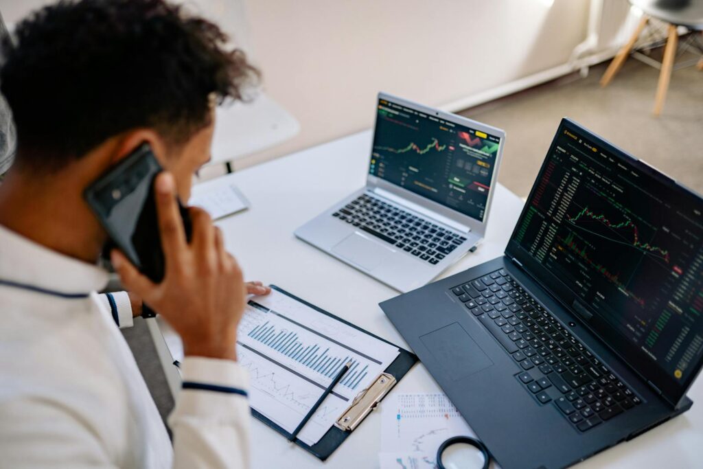 The Best CRM Software for Small Business: A Comprehensive Overview 15 Man analyzing stock market charts on laptops while talking on a cellphone.