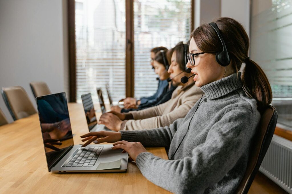 The Best CRM Software for Small Business: A Comprehensive Overview 13 Professional customer service team working in a modern office setting with headsets and laptops.