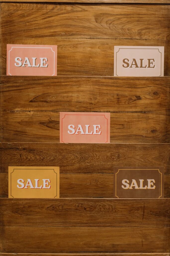 Vertical arrangement of sale signs on a wooden background, ideal for promotions.