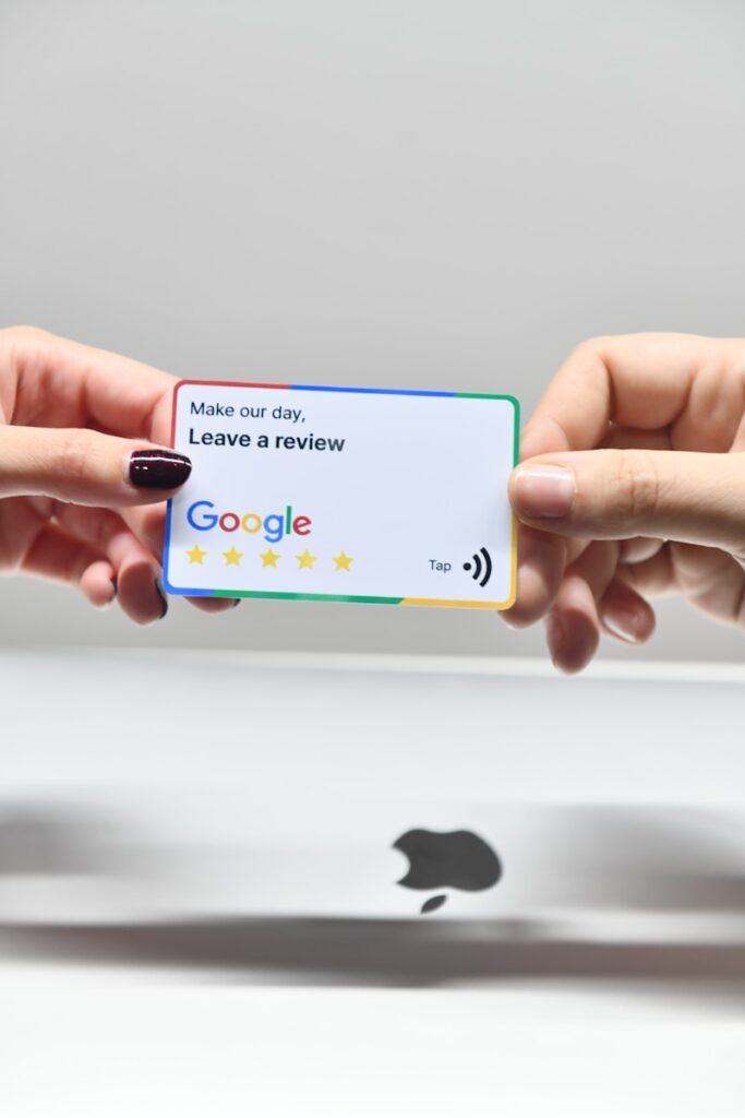 How to Delete a Google Review 8 two hands holding a google credit card in front of an apple logo