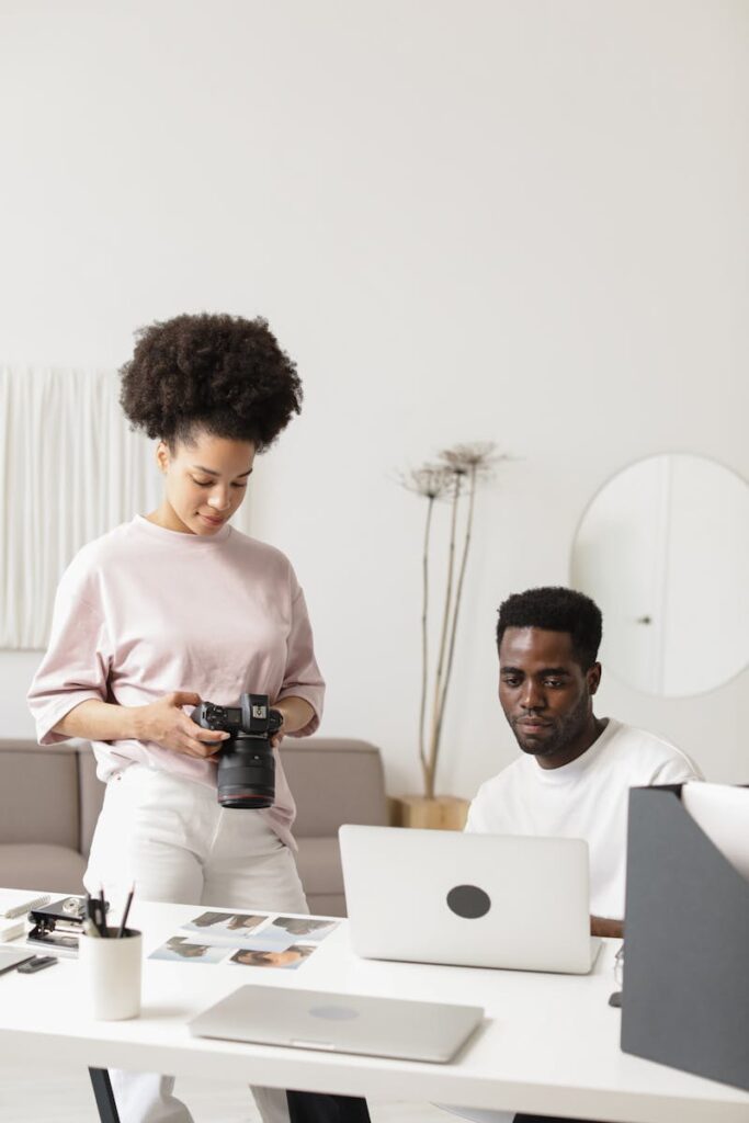 Two professionals collaborating in a bright, creative workspace with photography gear.