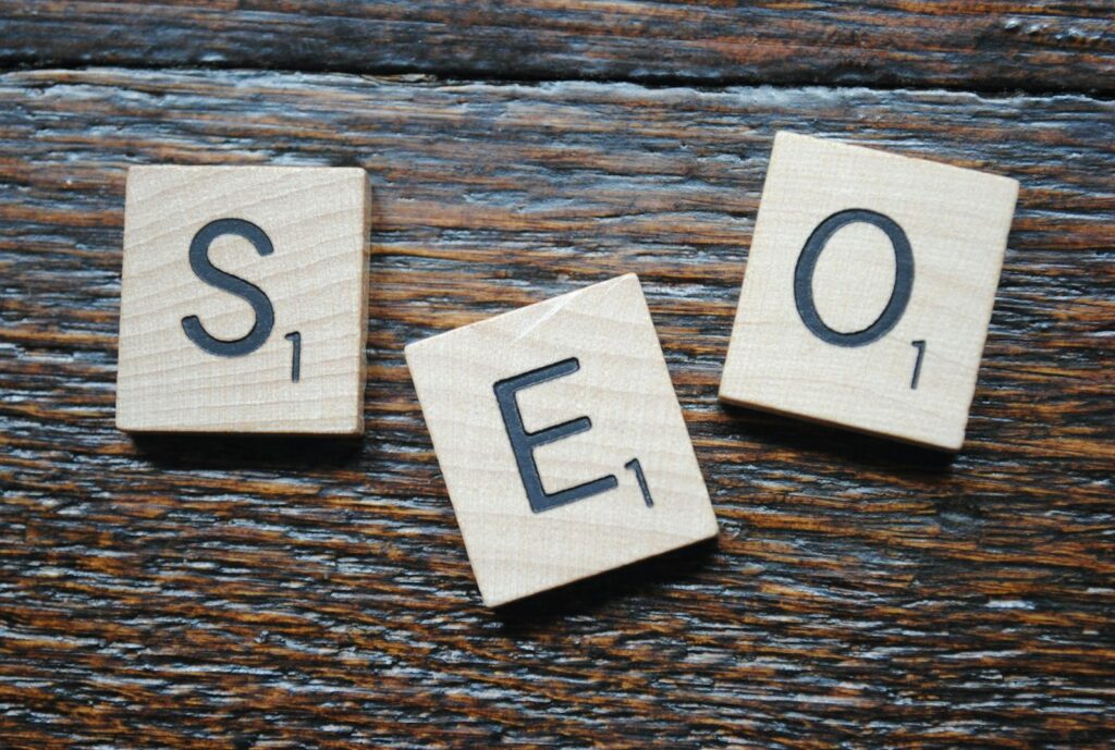 SEO Content Writing Services That Deliver Real Results 12 Close-up of Scrabble tiles spelling SEO on a wooden table for content strategy.