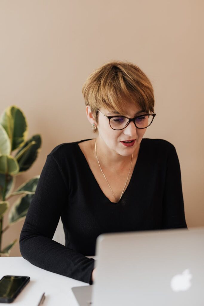 SEO Content Writing Services That Deliver Real Results 11 Content elegant adult female with short haircut in eyeglasses using laptop while working on business project in modern office