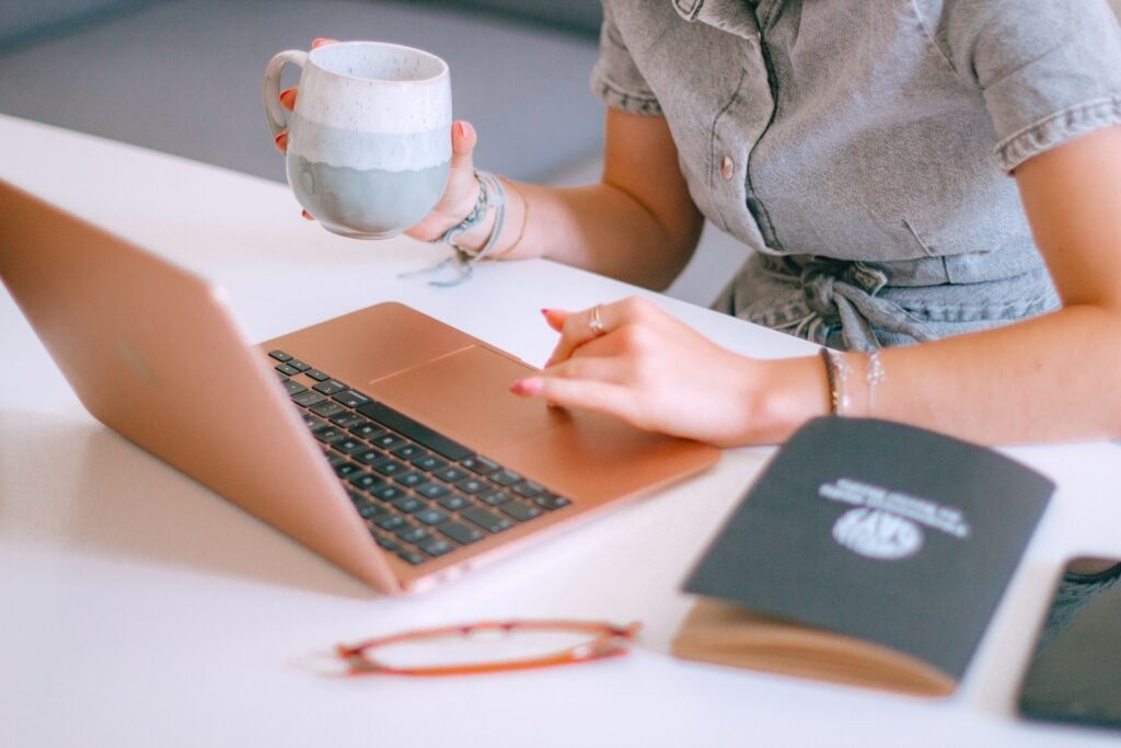 What Does a Social Media Manager Do—and Why Your Business Needs One 5 A woman sitting at a table with a laptop and a cup of coffee