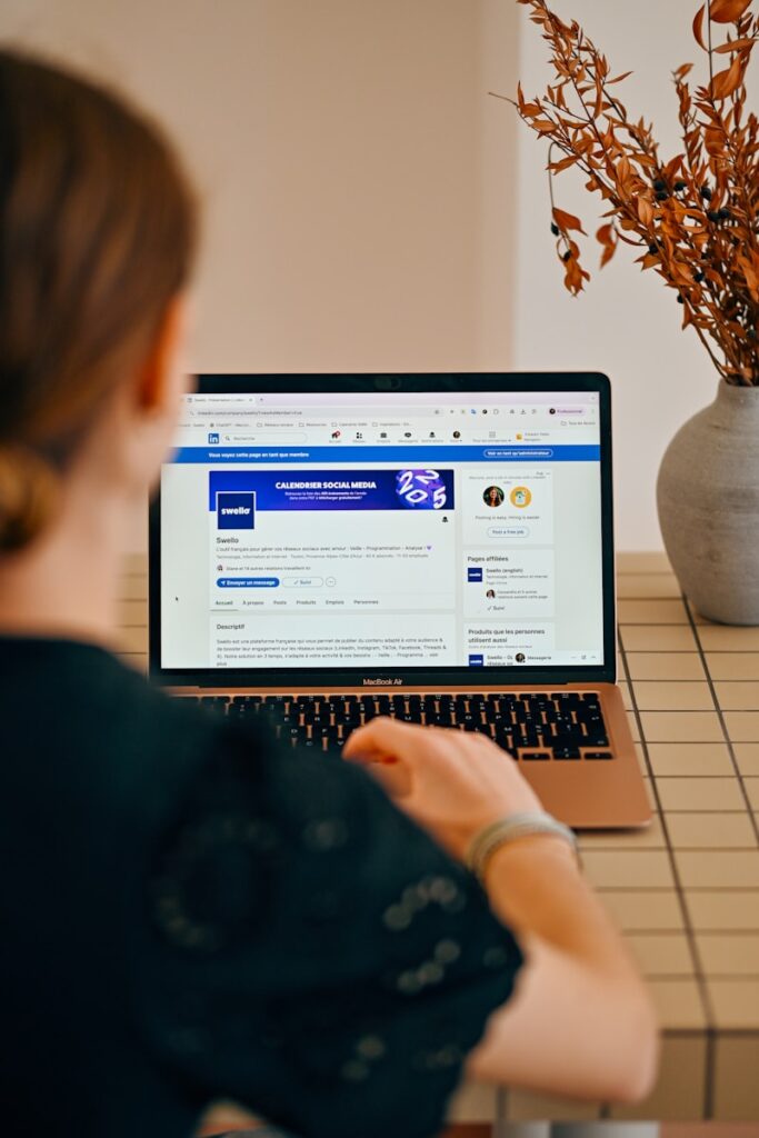 Woman using a laptop with social media open.