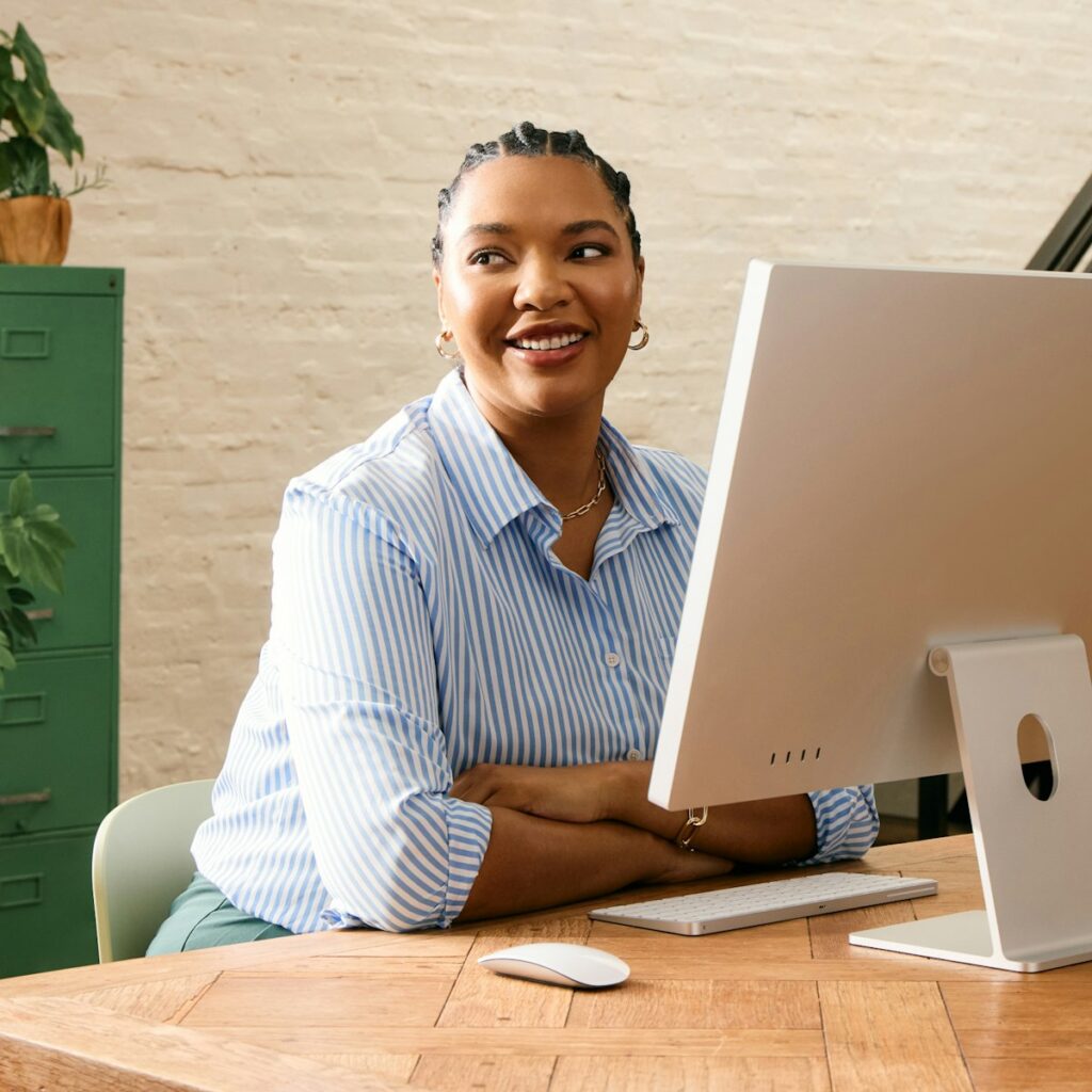 Social Media Specialist | Turning Followers into Loyal Customers 1 A woman smiling while working at a computer
