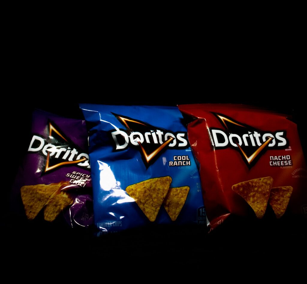 three bags of tortilla chips on a black background